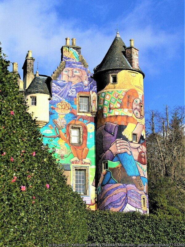 A castle stands tall with a colourful mural spanning the entire height of the building.