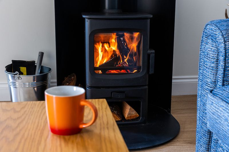 Orange mug on table in front of fire